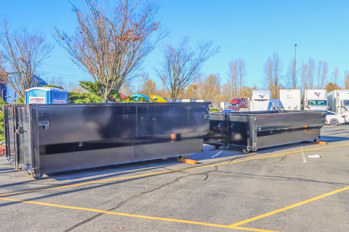 Professional dumpster rental service with roll-off container on residential driveway in Tigard